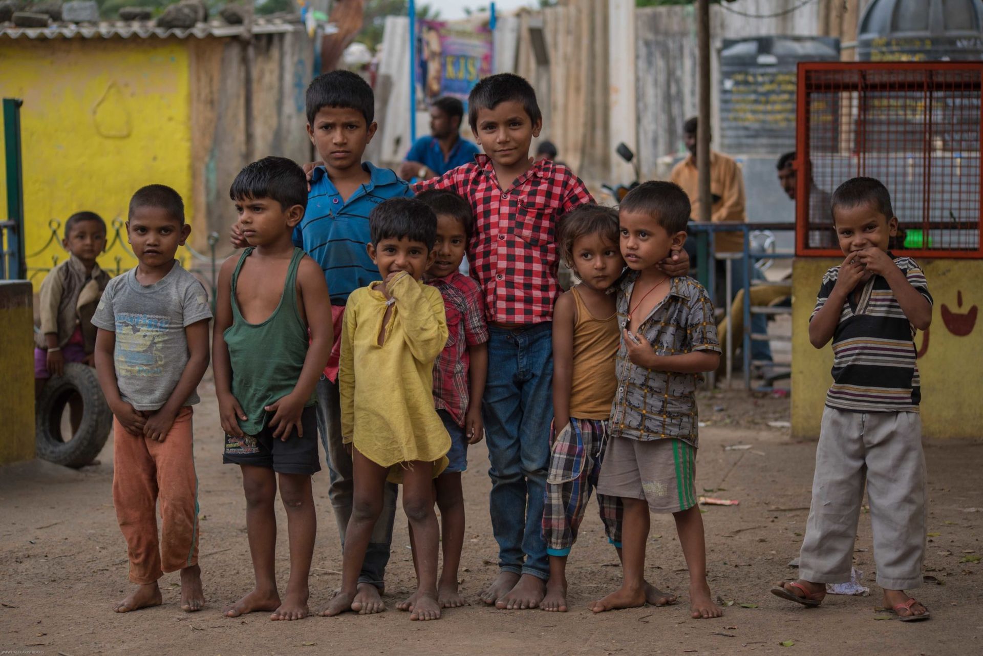 Niños con ropa con tierra posando frente a la cámara